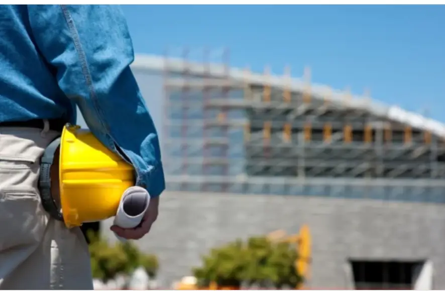A construction worker holding safety helmet