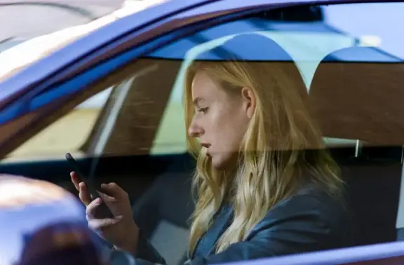 a woman on her phone in the car while driving