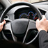 A driver with their hands on the steering wheel