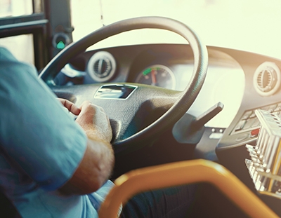 A bus driver holding a steering wheel. Negligent drivers can cause serious bus accidents.