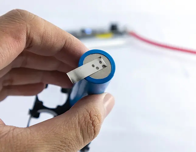 Hand holding lithium-ion battery.