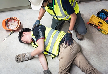 A construction worker is injured at his job site and is helped by a fellow worker.