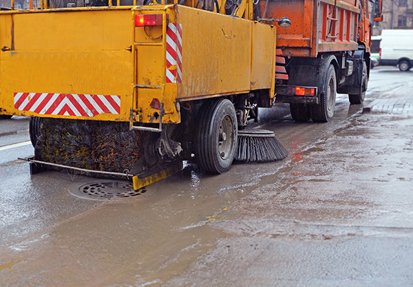 Street sweeper cleaning in the rain