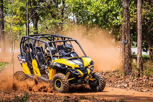 people in a side by side atv in mud
