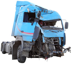 The wrecked cab of a big rig semi-trailer truck which has been badly damaged in a truck crash.