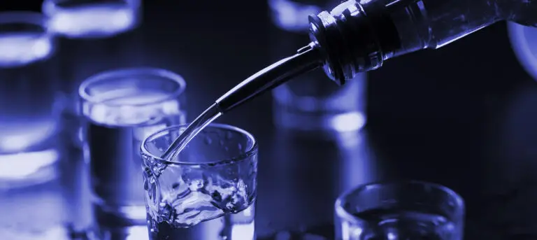 Shot glasses being filled with alcohol - fraternity hazing