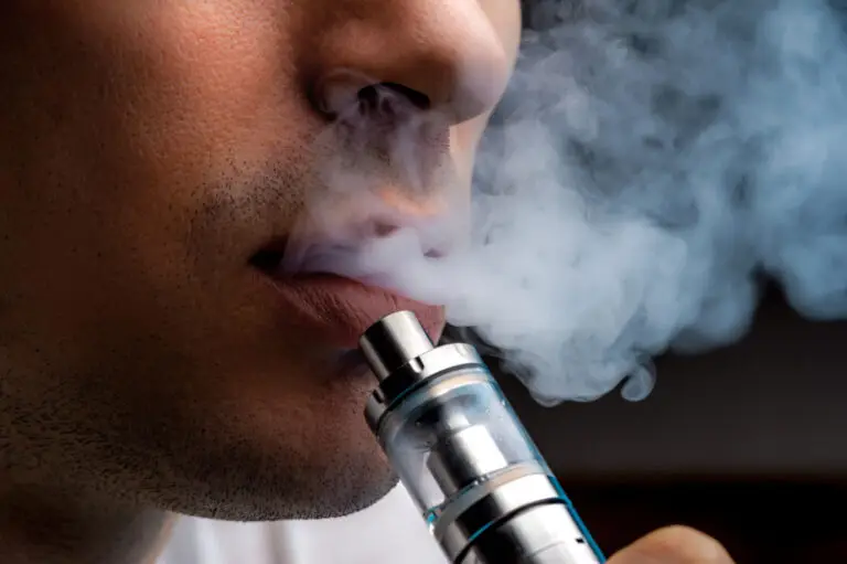 A young person vaping using an e-cigarette device.