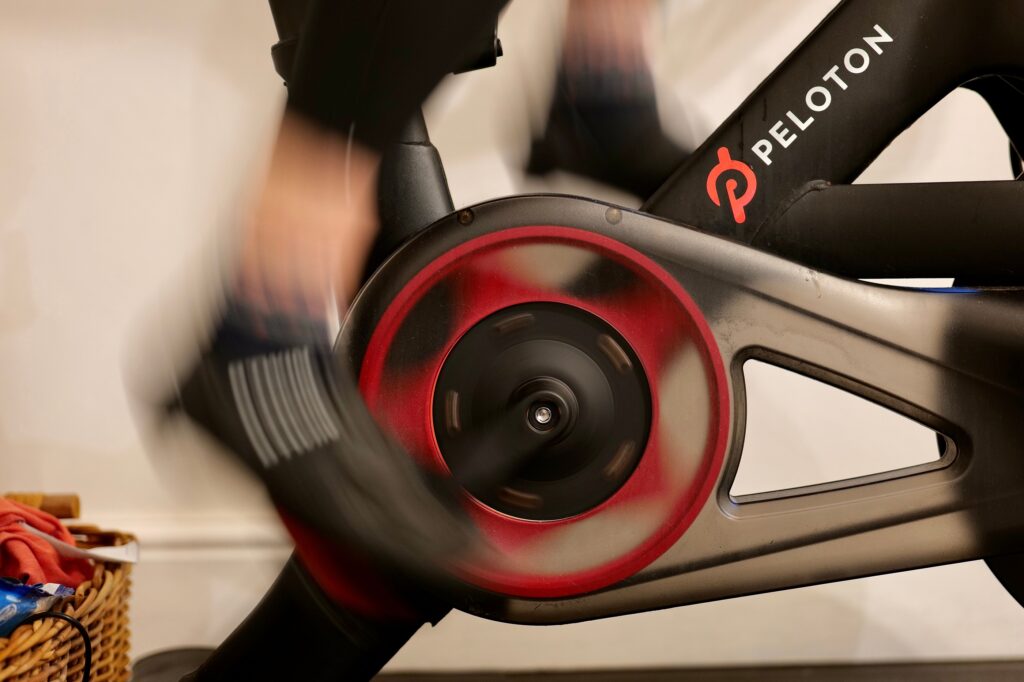 A person exercising at home on a Peloton exercise bike.