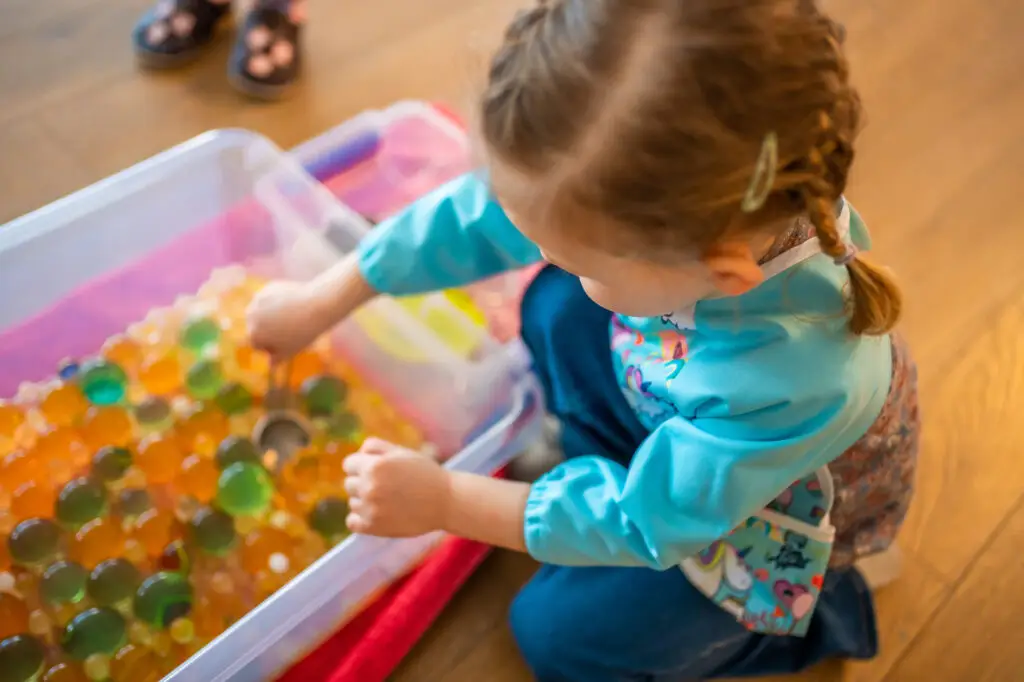 A child playing with dangerous water beads