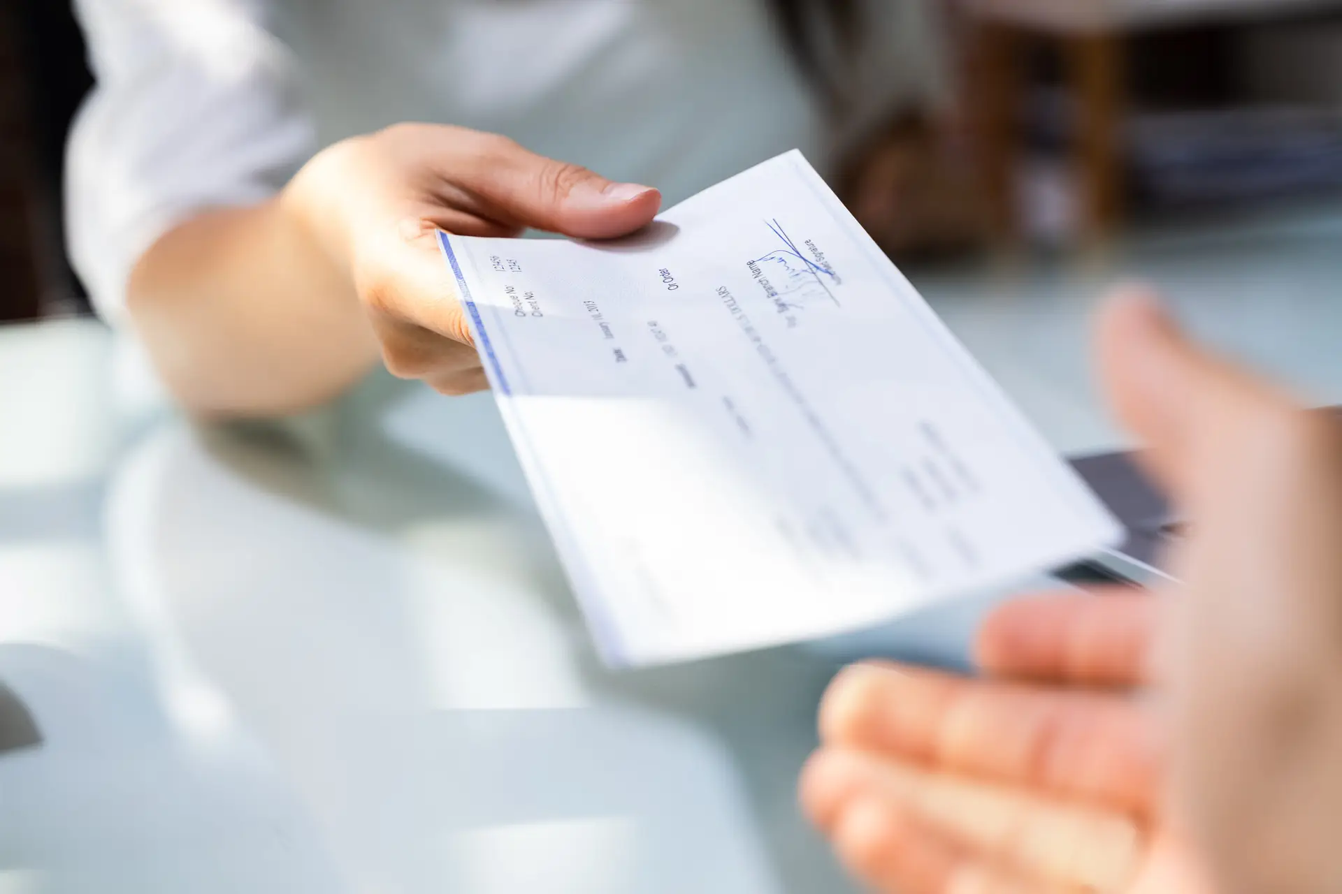 an employee being handed their paycheck.